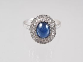 A white metal, sapphire cabochon and diamond set cluster ring, size S