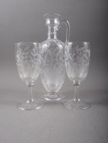 A late 19th century engraved carafe, 11" high, and a pair of matching glasses