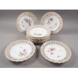 Ten KPM porcelain plates with reticulated and gilded borders and hand painted floral centres, 9" dia