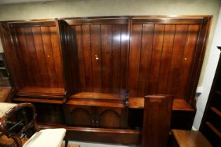 An oak three-section open bookcase, the centre section enclosed two panelled doors with flanking