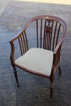 An Edwardian walnut carved vase splat back tub elbow chair with padded seat, on turned supports