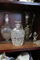 A cut glass claret jug, a cut glass decanter and stopper, and one other claret jug