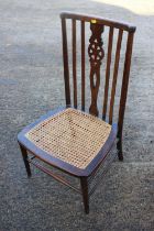 A Windsor lath back nursing chair with cane seat, on turned and stretchered supports, and a