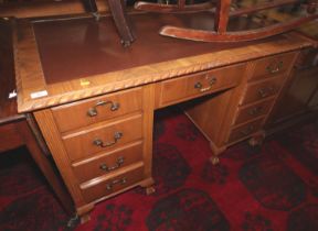 A mid 20th century carved walnut double pedestal desk with tooled lined top over nine drawers, on
