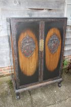 A 1930s Chinese carved hardwood wardrobe enclosed two doors, on shaped supports, 36" wide x 20" deep