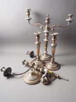 A pair of silver plated three-light candelabra and two similar single-light candlesticks