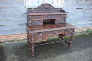 A late 19th century carved oak desk, the upper gallery fitted five drawers over five further