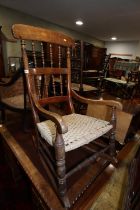 An early 20th century polished as walnut spindle back rocking chair with string seat