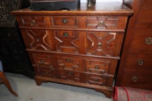 An early 18th century oak chest of four long drawers with fielded panel fronts and ring handles,