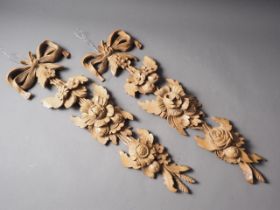 A matched pair of carved pine plaques with floral decoration, 24" long