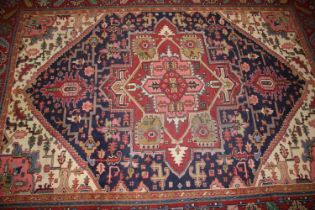 A Caucasian wool rug with central medallion on a blue ground, geometric and floral designs and