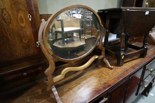 A mahogany skeleton toilet mirror with oval bevelled plate, 16 1/2" x 12"