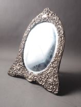 A silver framed easel mirror with scrolled decoration and bevelled plate, 12 1/2" high overall,