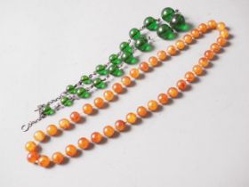 A green amber Bakelite bead necklace, the largest round bead, 21mm dia, 47.9g gross, and an egg yolk