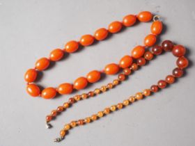 A coral coloured amber Bakelite bead necklace, the largest oval bead, 19mm long, 66.3g gross, and