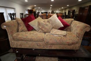 A chesterfield type settee with loose seat and back cushions, upholstered in a floral tapestry,