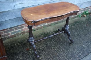 A walnut shaped fold-over top card table, on carved turned and stretchered supports, 37" wide x