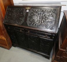 A 19th century carved oak fall front bureau, the interior fitted drawers and pigeonholes, over two