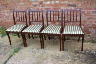 A set of four reproduction mahogany side chairs with drop-in seats and a carver chair with striped