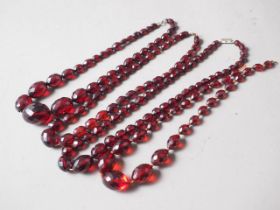 Four various cherry amber Bakelite facetted bead necklaces, 108g gross