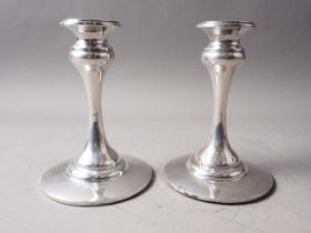 A pair of silver candlesticks, on circular filled bases, 6 1/4" high