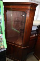 A mahogany corner display cabinet, the upper section enclosed glazed panel door over cupboard, on