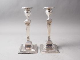 A pair of Edwardian silver pillar candlesticks, on square bases, 8" high