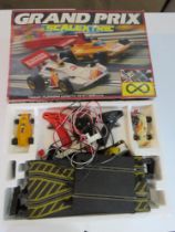 Scalextric Grand Prix track and two racing cars with controllers.