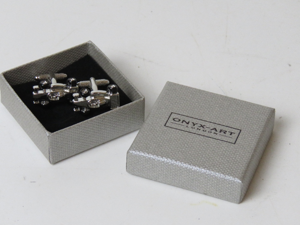 A pair of as new cufflinks in the form of F1 racing cars with black enamel wheels by Onyx-Art in