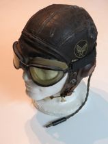 A WWII US Air Force type B-6 helmet with WWII goggles made by Fisher Spring Co and Radio headset