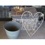 A grey wicker lidded laundry basket together with a white metal notice board,