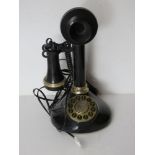 A contemporary black plastic telephone in the style of a vintage candlestick phone.