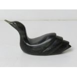 An Inuit green soapstone carving of a bird at rest on water,