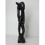 An African hard wood carving being an abstract of a man blowing a horn, standing 37cm high.