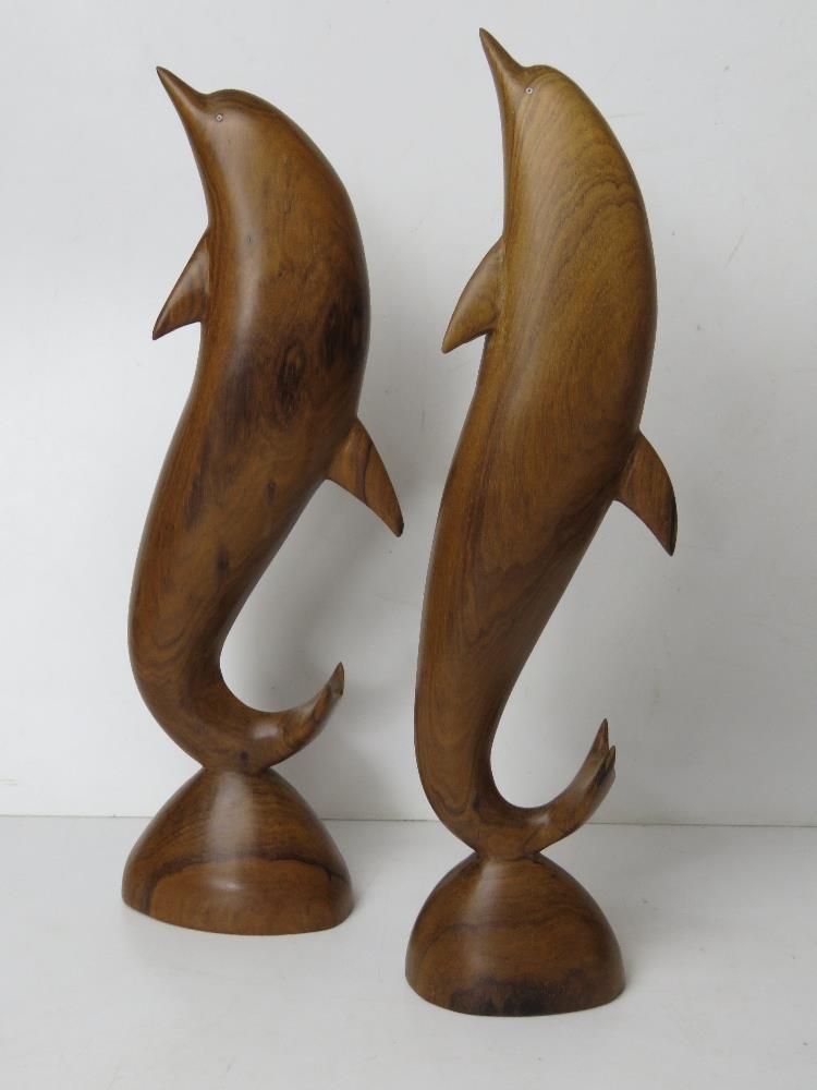 A pair of carved wooden dolphin figurines, one having repair to dorsal fin, each standing 37cm high.