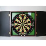 A dartboard within wall mounting case.