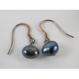 A pair of silver and black coloured pearl earrings. In presentation box.