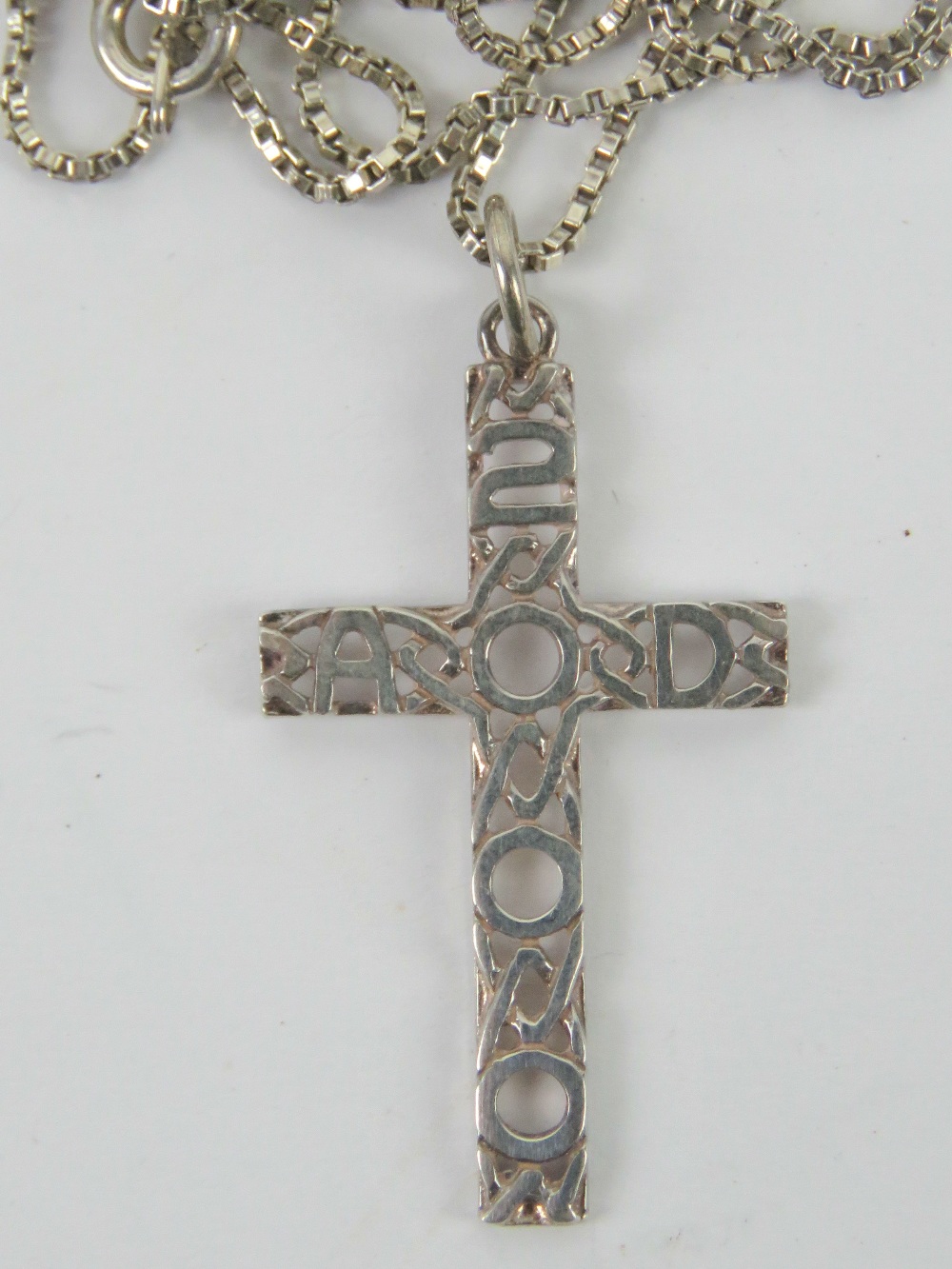 A white metal crucifix pendant having Celtic pattern with 2000 AD upon, no apparent hallmarks,