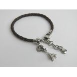 A designer charm bracelet by Fossil, braided leather with Eiffel Tower charm upon.
