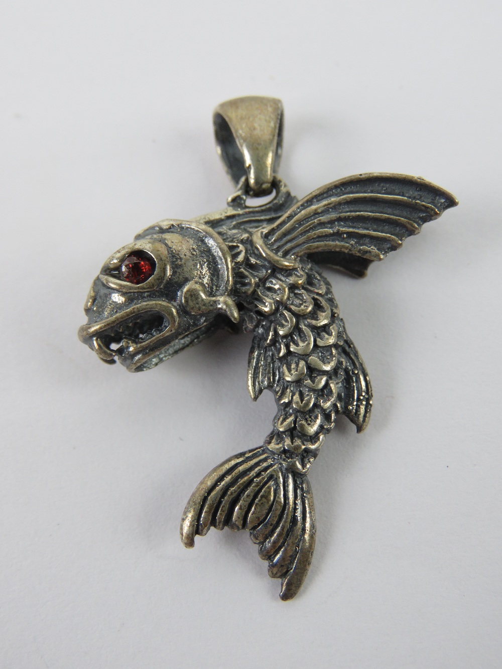 A flying fish pendant having red stone eyes, stamped 925, 4.77cm in length, 8.3g.