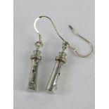 A pair of earrings in the form of lighthouses.