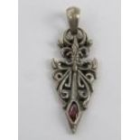 A white metal and red stone pendant of gothic form, stamped 925 and measuring 5cm in length.