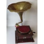 A vintage gramophone with a wind mechanism and handle, having brass horn,
