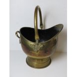 A brass helmet style coal scuttle with swing handle over.