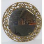 A 1950s circular wall mirror by Atsonfa, having carved and gilded frame, bevelled edge glass,