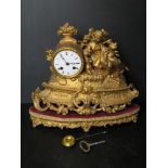 A 19thC continental mantel clock raised over a matching velvet base.