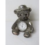 A silver plated Teddy bear having clock to stomach marked WM Widdop, standing approx 9cm high.