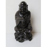 A carved Oriental wooden figurine of a deity.