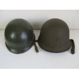 A US M1 helmet and a 1953 French helmet.