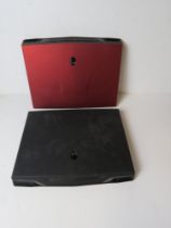 Two Alienware gaming laptops, one red, o